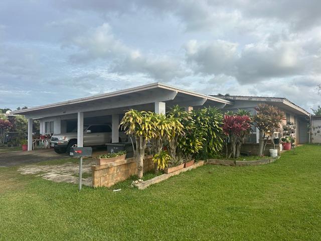 view of side of home featuring a carport and a yard