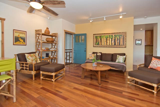 living room with ceiling fan, rail lighting, and wood-type flooring