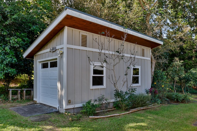 view of outdoor structure with a lawn and a garage