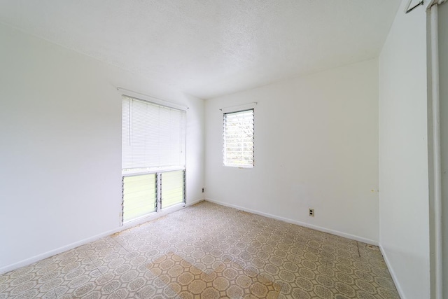 unfurnished room featuring a textured ceiling