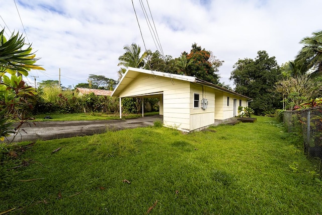 view of side of home with a carport and a lawn