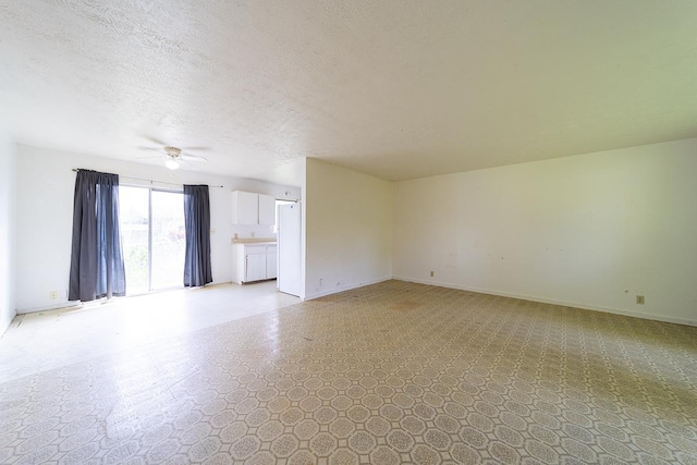 unfurnished living room with ceiling fan and a textured ceiling