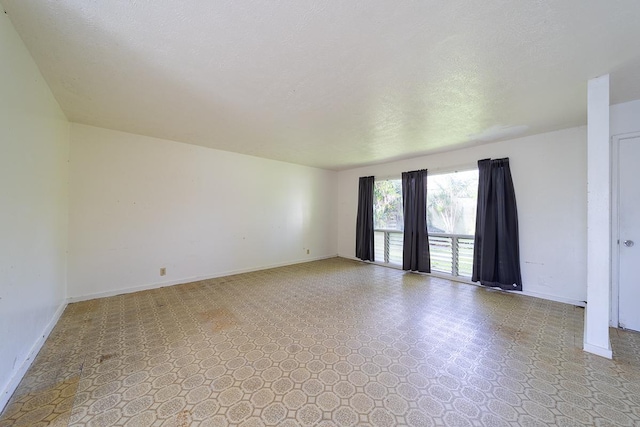 unfurnished room with a textured ceiling