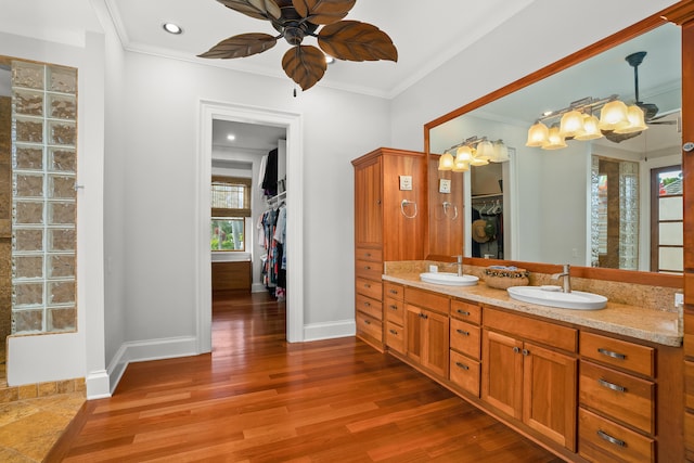 bathroom featuring vanity, hardwood / wood-style flooring, ceiling fan, and ornamental molding