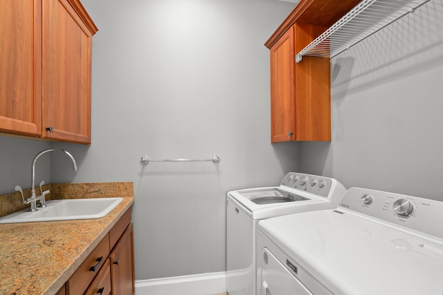 laundry area with washing machine and clothes dryer, sink, and cabinets