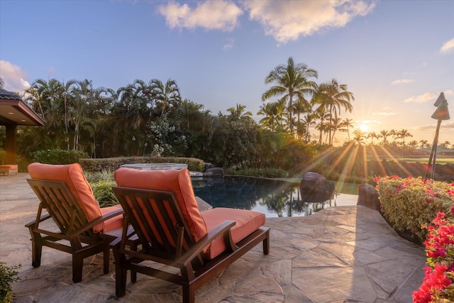 patio terrace at dusk featuring a water view