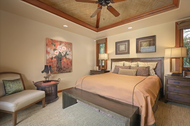 bedroom with ornamental molding, ceiling fan, and a tray ceiling