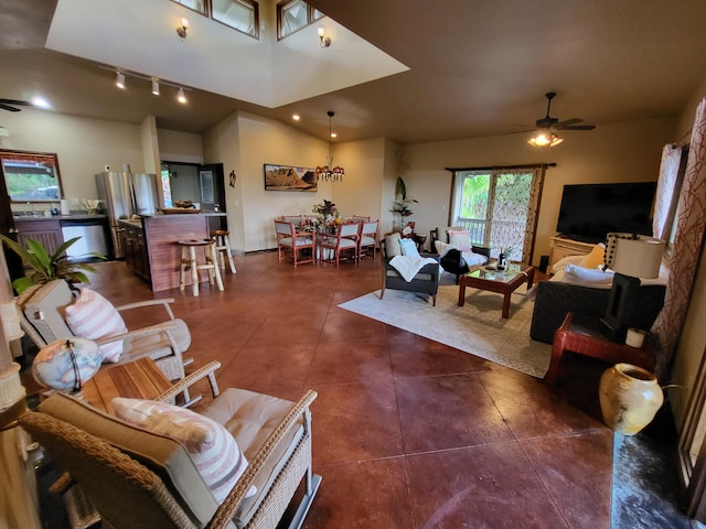 living room with ceiling fan, dark tile patterned floors, track lighting, and high vaulted ceiling