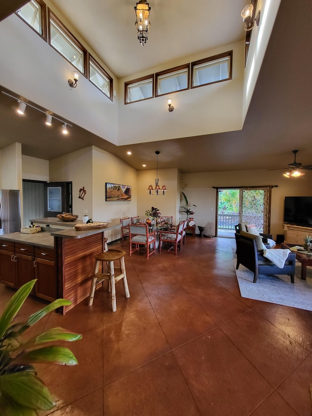 dining area with a towering ceiling and an inviting chandelier