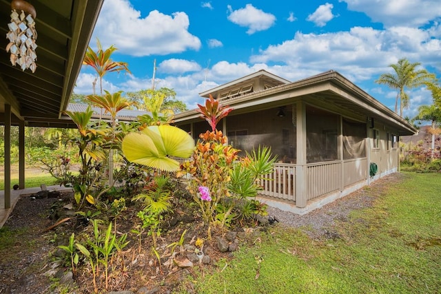 view of property exterior featuring a yard and a sunroom