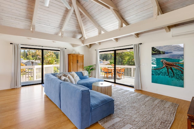 living room featuring lofted ceiling with beams, a wealth of natural light, light wood-style floors, and an AC wall unit