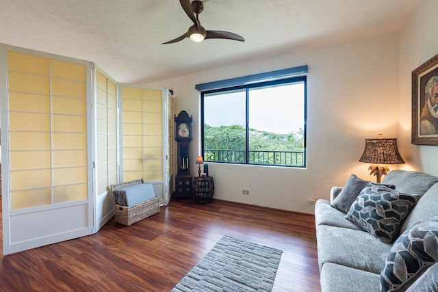 unfurnished living room featuring dark wood-type flooring and ceiling fan