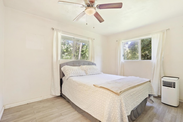 bedroom with light hardwood / wood-style floors and ceiling fan