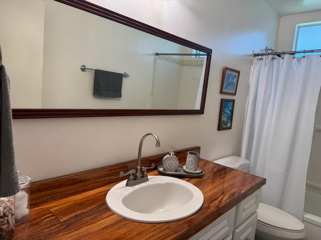 full bathroom featuring shower / bath combo, vanity, and toilet