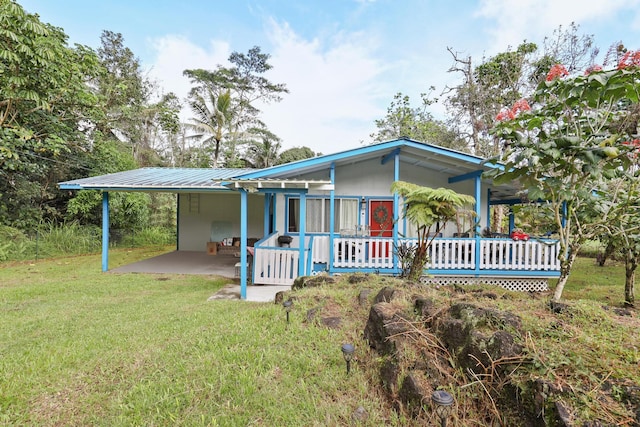 back of property with a yard and a carport