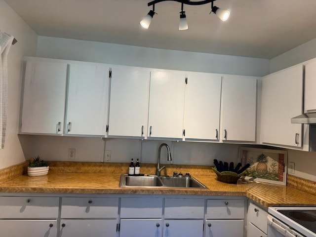 kitchen with white cabinetry, sink, extractor fan, and range