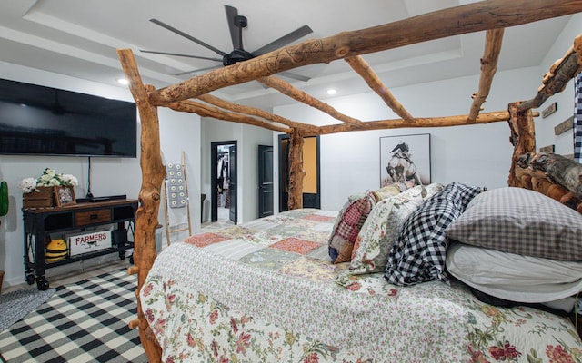 bedroom with ceiling fan and a walk in closet