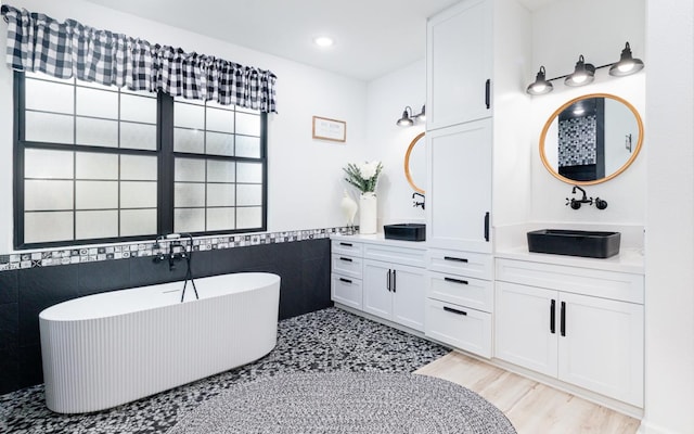 bathroom featuring vanity, tile walls, and a bathing tub