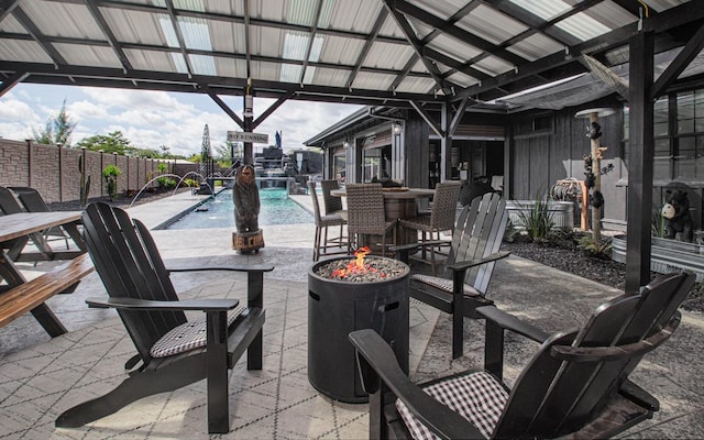 view of patio featuring a fenced in pool, an outdoor fire pit, and pool water feature