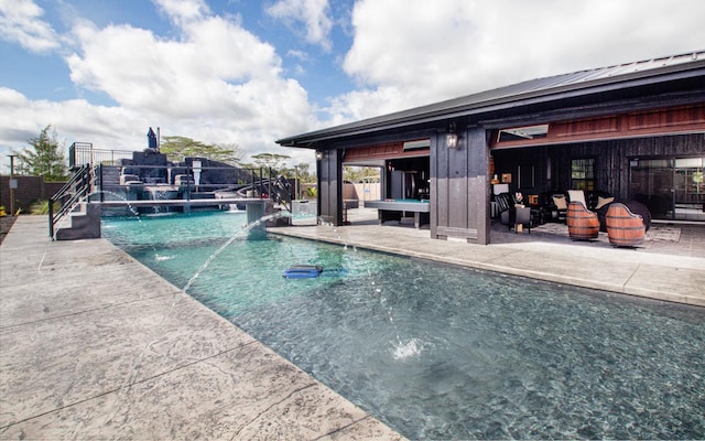 view of swimming pool featuring pool water feature and a patio area