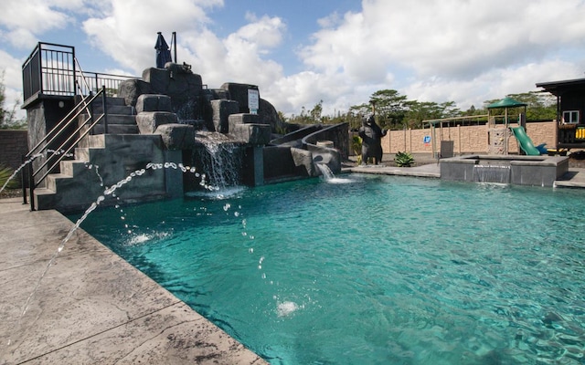 view of swimming pool with a hot tub and pool water feature