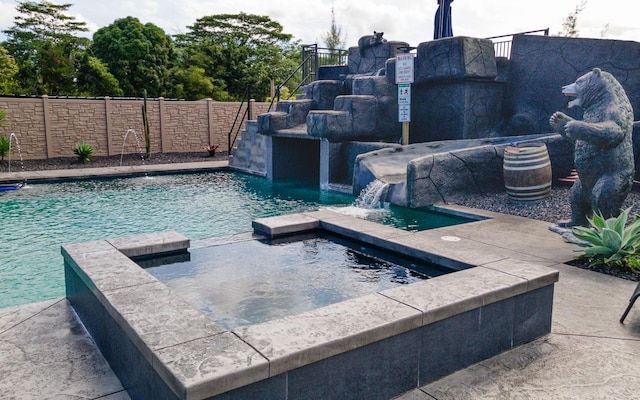 view of swimming pool featuring pool water feature and a hot tub