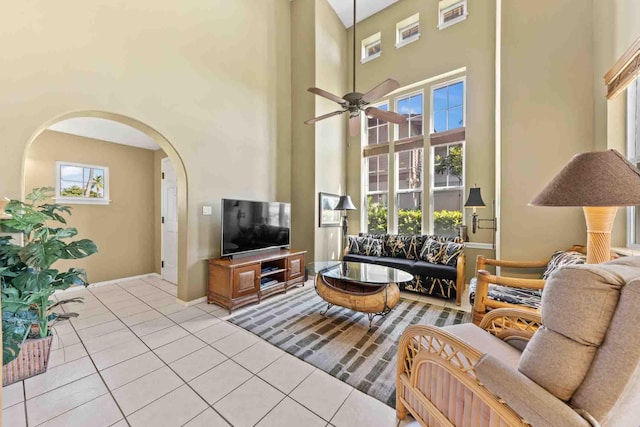 tiled living room with a towering ceiling and ceiling fan