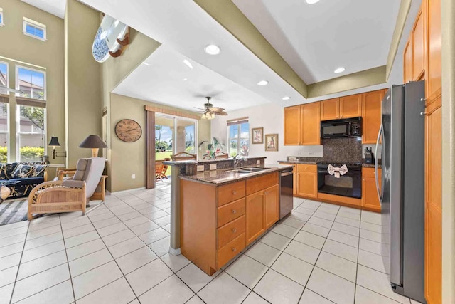 kitchen with ceiling fan, sink, black appliances, an island with sink, and light tile patterned flooring