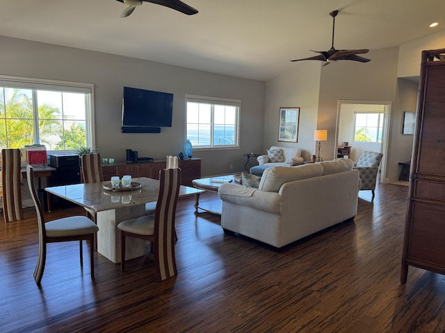 living room with vaulted ceiling, ceiling fan, and dark wood-type flooring