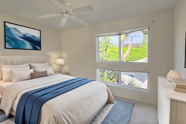 bedroom featuring multiple windows, light carpet, and ceiling fan