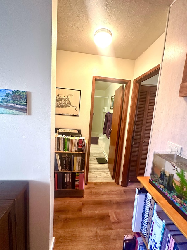 hallway featuring a textured ceiling and hardwood / wood-style flooring