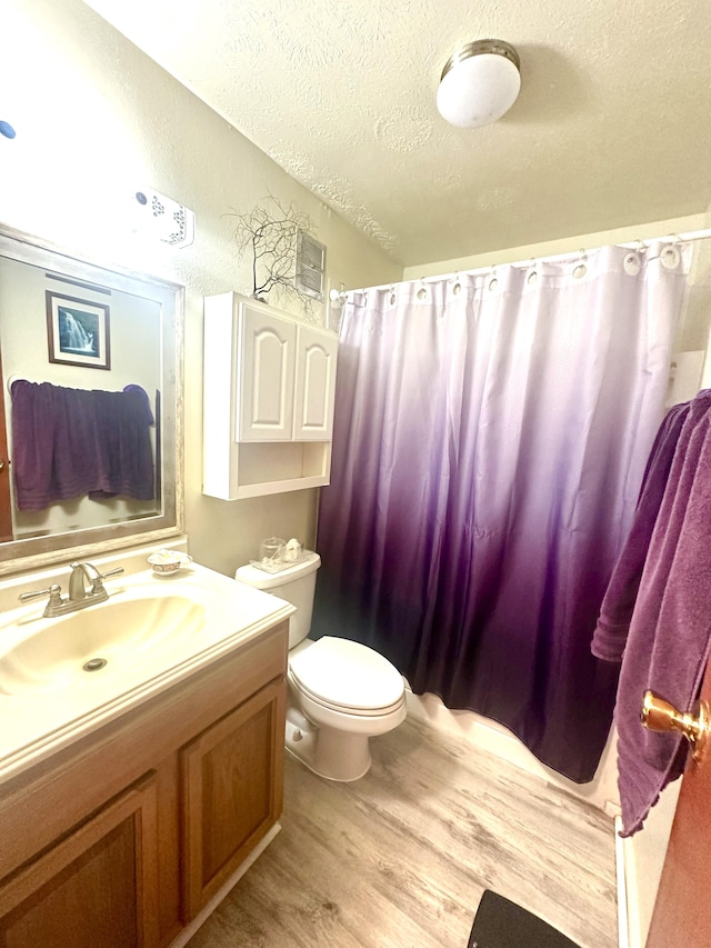 bathroom with vanity, hardwood / wood-style floors, a textured ceiling, and toilet