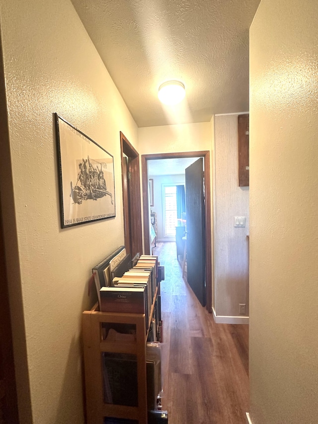 hall featuring dark hardwood / wood-style floors and a textured ceiling