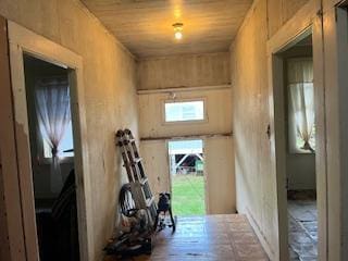 hallway with wood walls and wood ceiling