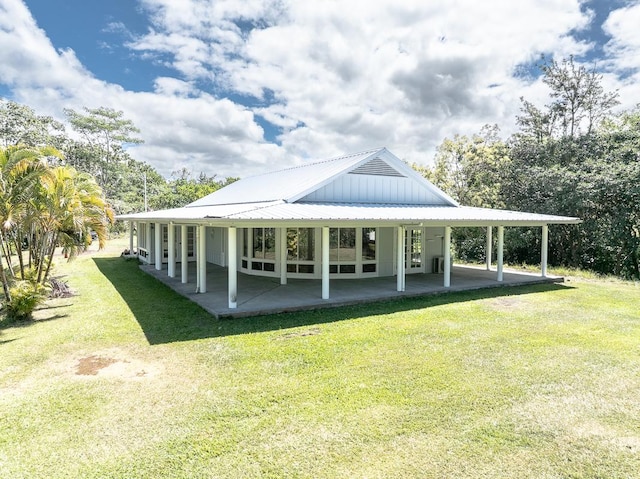 view of community featuring a yard, a carport, and a patio