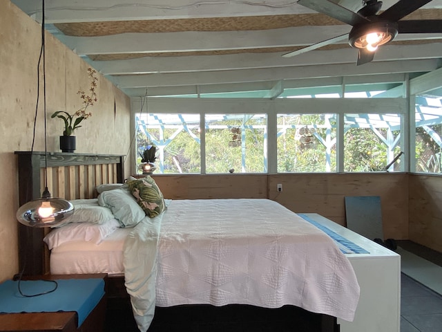 tiled bedroom featuring beamed ceiling and ceiling fan