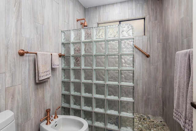 bathroom featuring a tile shower, sink, a bidet, and toilet