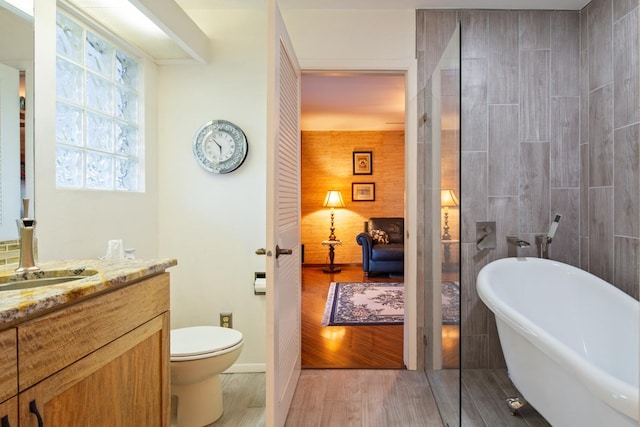 bathroom with hardwood / wood-style floors, a bathtub, toilet, and vanity