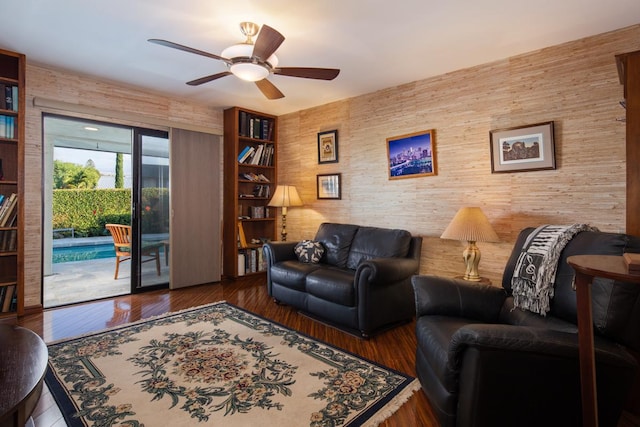 living room with ceiling fan and dark hardwood / wood-style floors