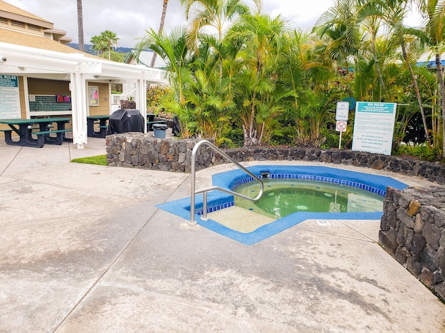 view of pool featuring area for grilling and a hot tub