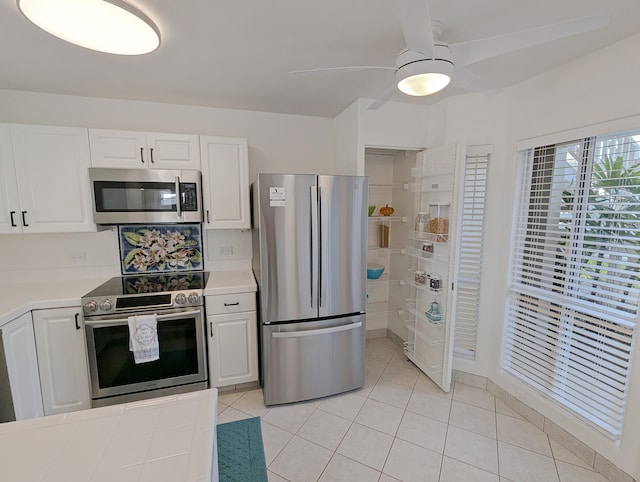 kitchen featuring light tile patterned flooring, ceiling fan, appliances with stainless steel finishes, and white cabinetry