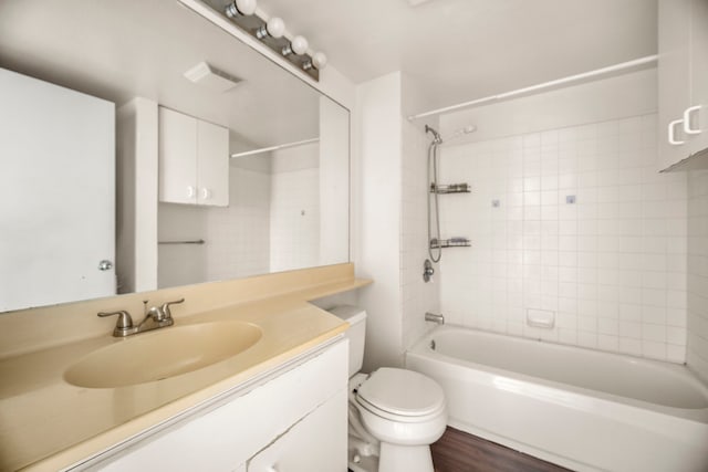 full bathroom featuring tiled shower / bath, wood-type flooring, vanity, and toilet