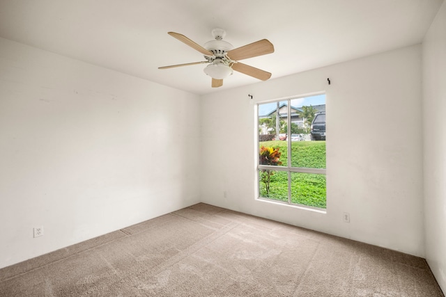 carpeted spare room with ceiling fan