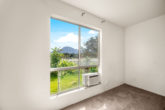 unfurnished room featuring cooling unit, a mountain view, a healthy amount of sunlight, and carpet flooring