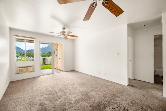 carpeted spare room featuring ceiling fan, a mountain view, and an AC wall unit