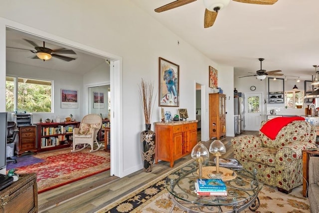 living room featuring hardwood / wood-style flooring, sink, and vaulted ceiling