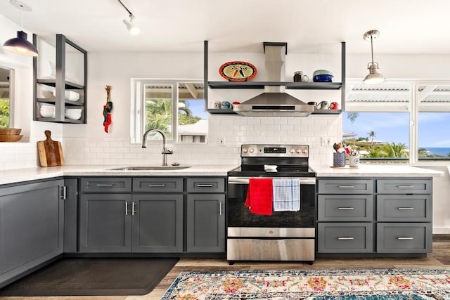 kitchen featuring gray cabinetry, stainless steel electric range, sink, and decorative light fixtures