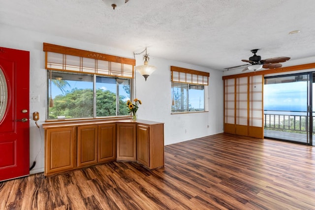 kitchen with a textured ceiling, ceiling fan, and dark hardwood / wood-style flooring