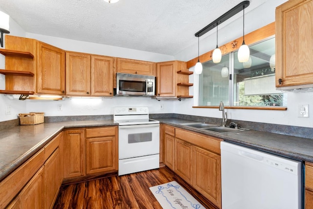 kitchen with white appliances, a textured ceiling, decorative light fixtures, dark wood-type flooring, and sink