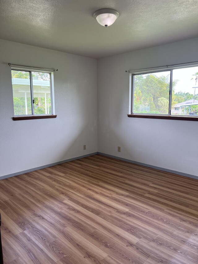 spare room featuring a textured ceiling and hardwood / wood-style floors